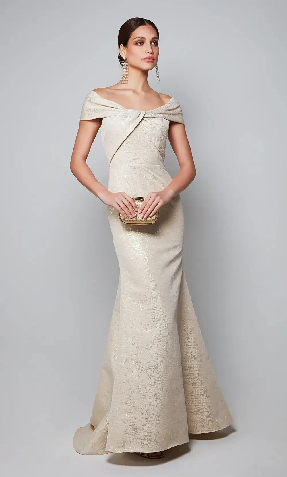 model is wearing a gold off the shoulder mothers gown