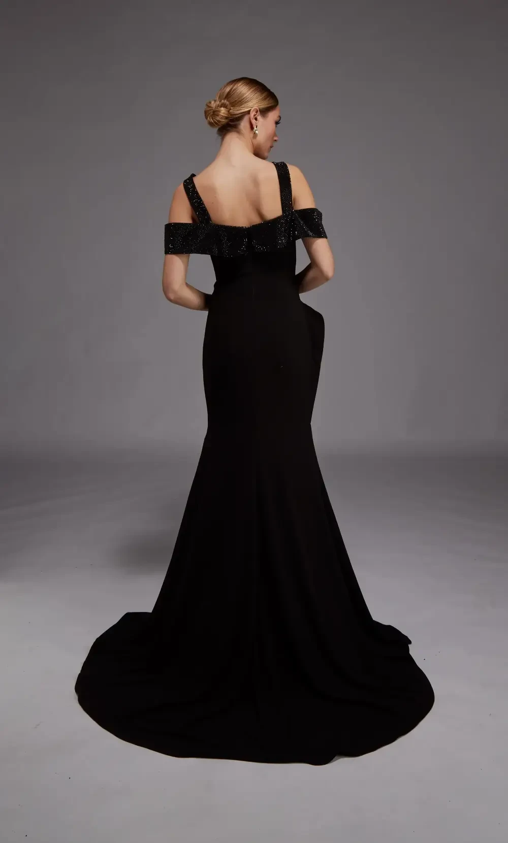 model is wearing a black off the shoulder mothers gown