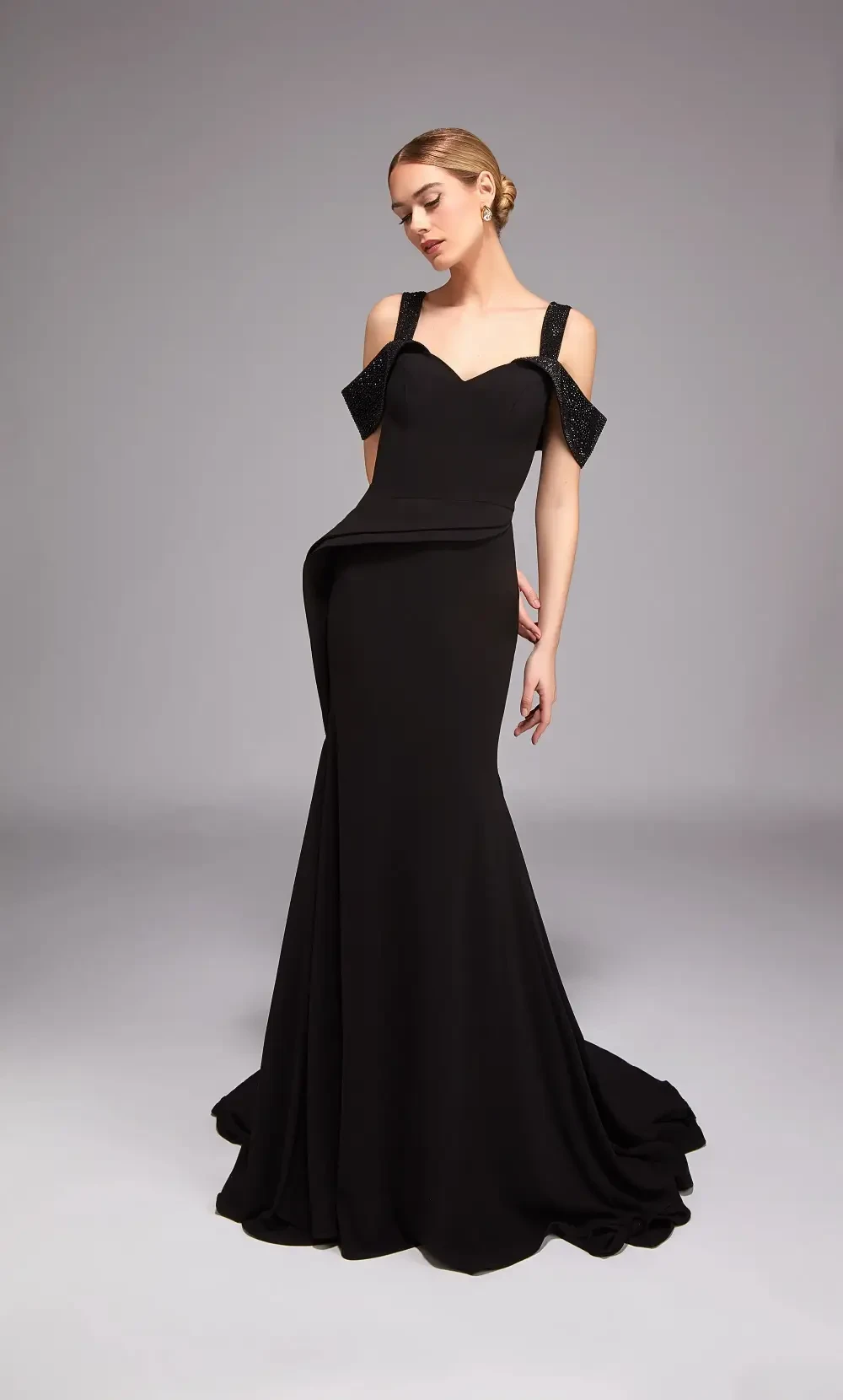 model is wearing a black off the shoulder mothers gown