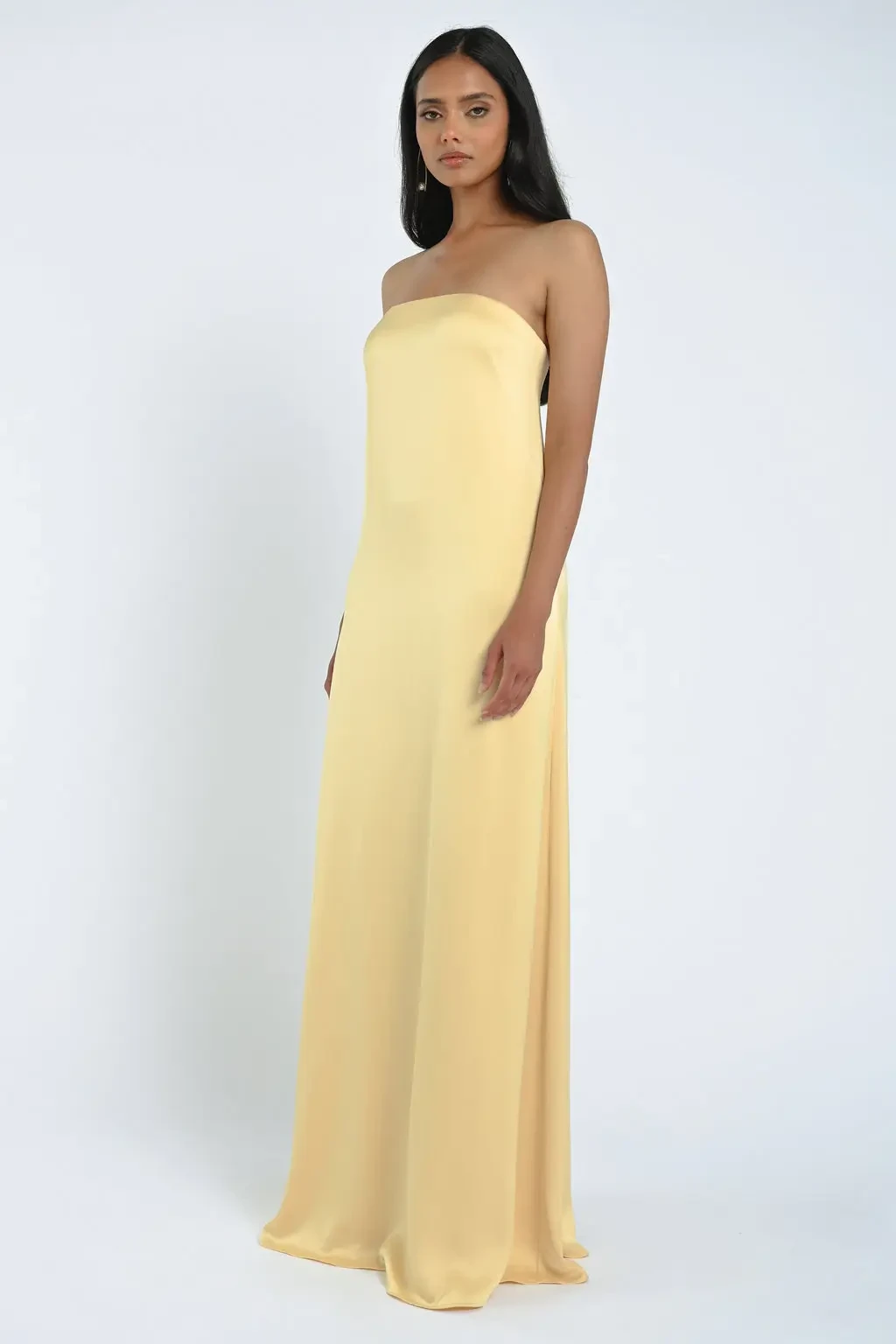 A woman wearing a strapless, floor-length yellow dress.