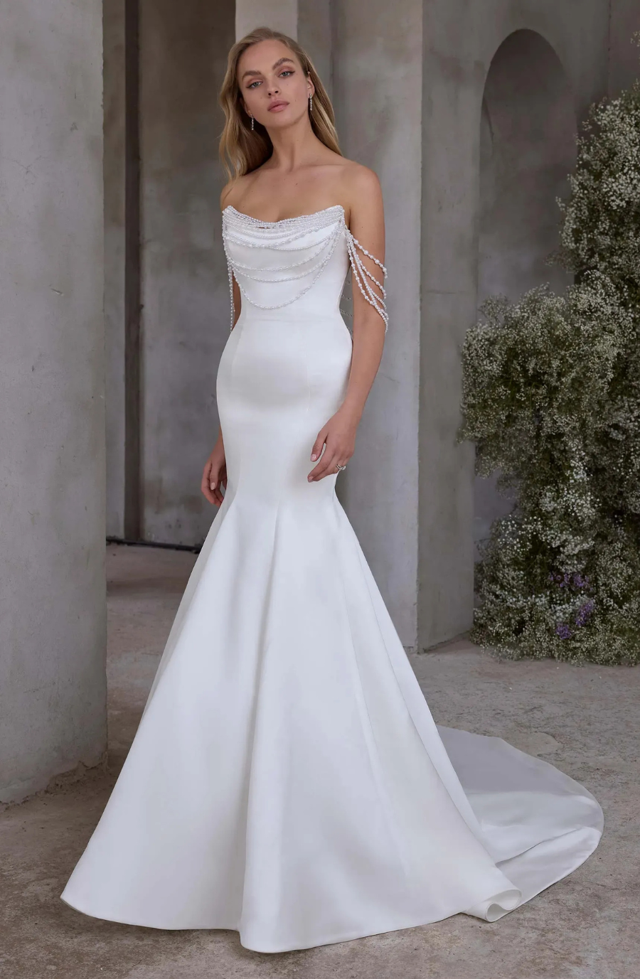 Model is wearing a minimalist wedding gown showcasing a simple, elegant design with understated sophistication.