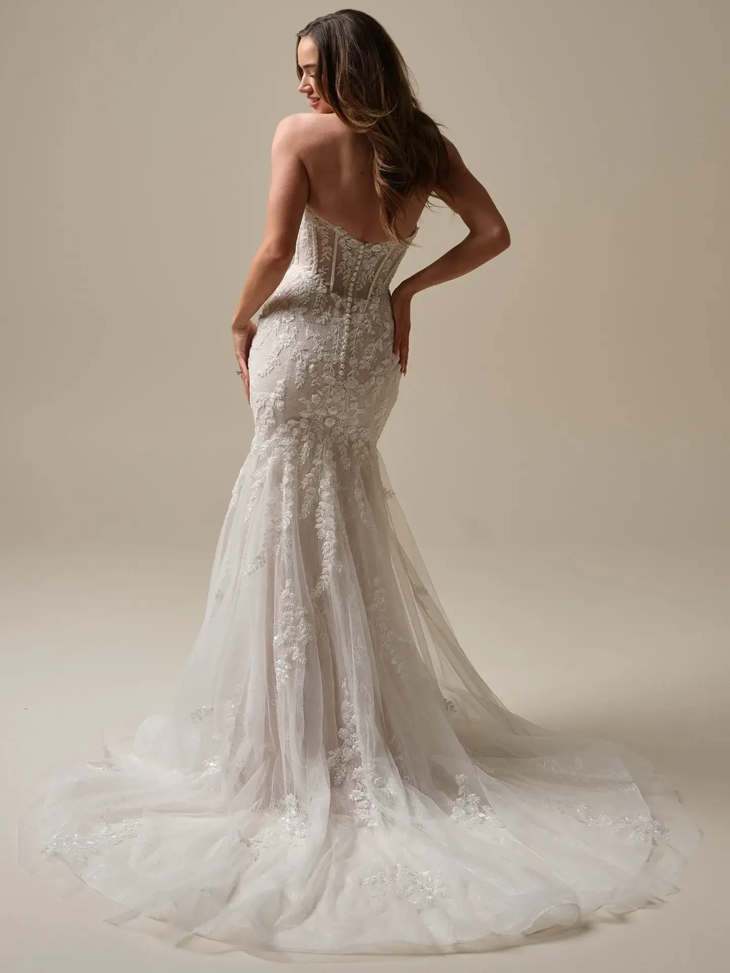 Model is wearing an off the shoulder lace mermaid wedding dress with a corset bodice