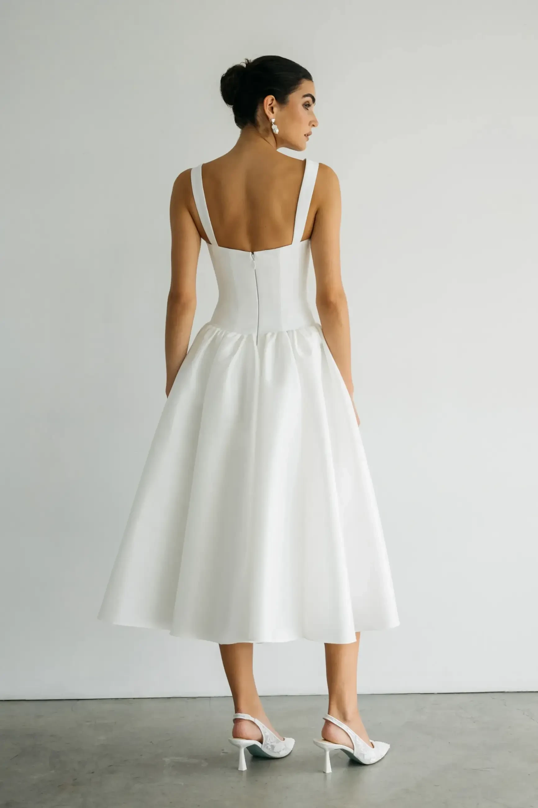 model is wearing a tea length bridal dress by jenny yoo