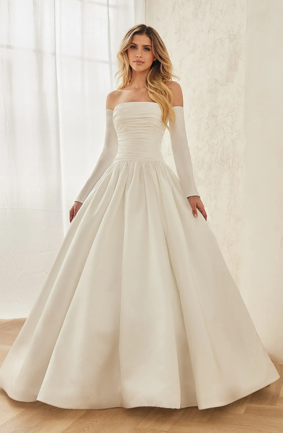 Model is wearing a satin wedding gown with a smooth, glossy finish that drapes beautifully.