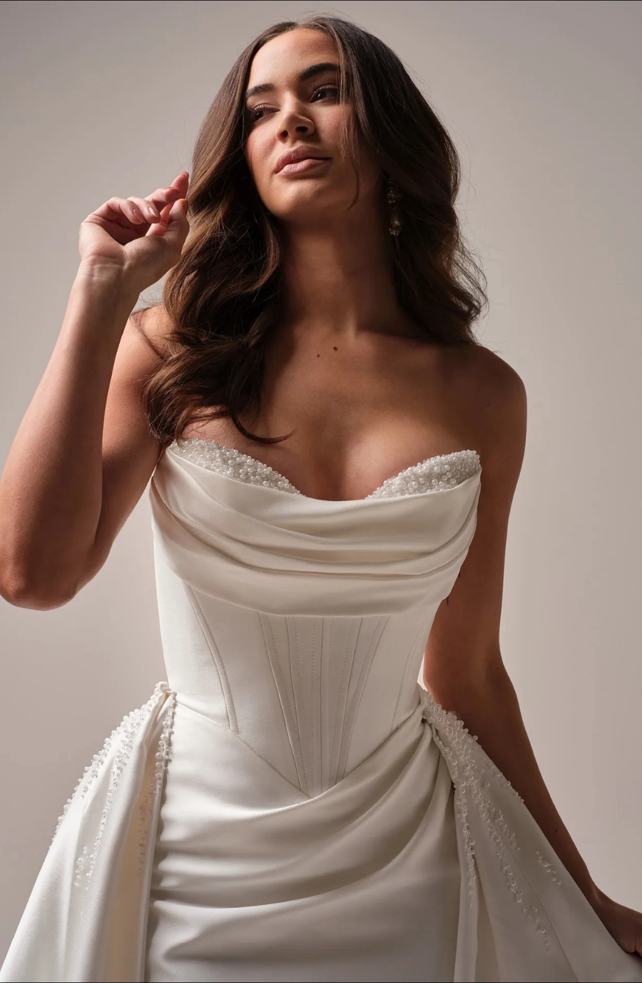Model is wearing a satin wedding gown that combines timeless elegance with a luminous sheen.