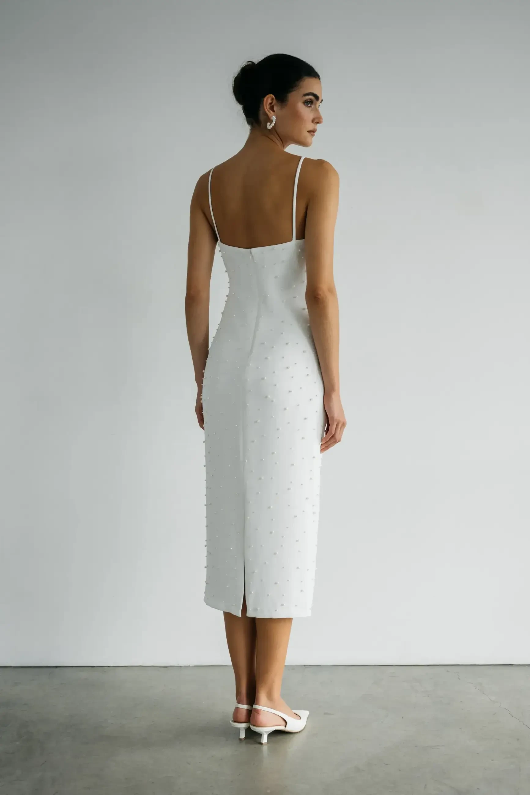 model is wearing a tea length bridal dress with scattered pearls all over