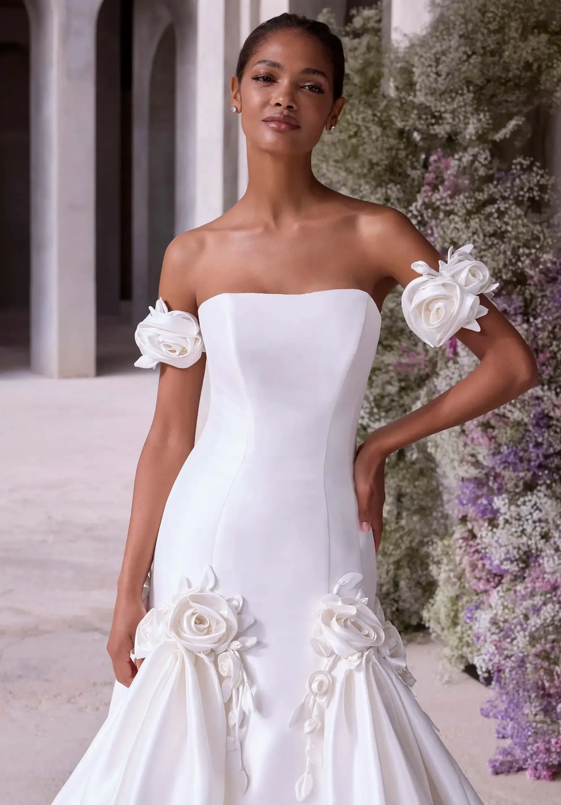 Model is wearing a wedding gown adorned with 3D floral appliques for a textured, romantic look.