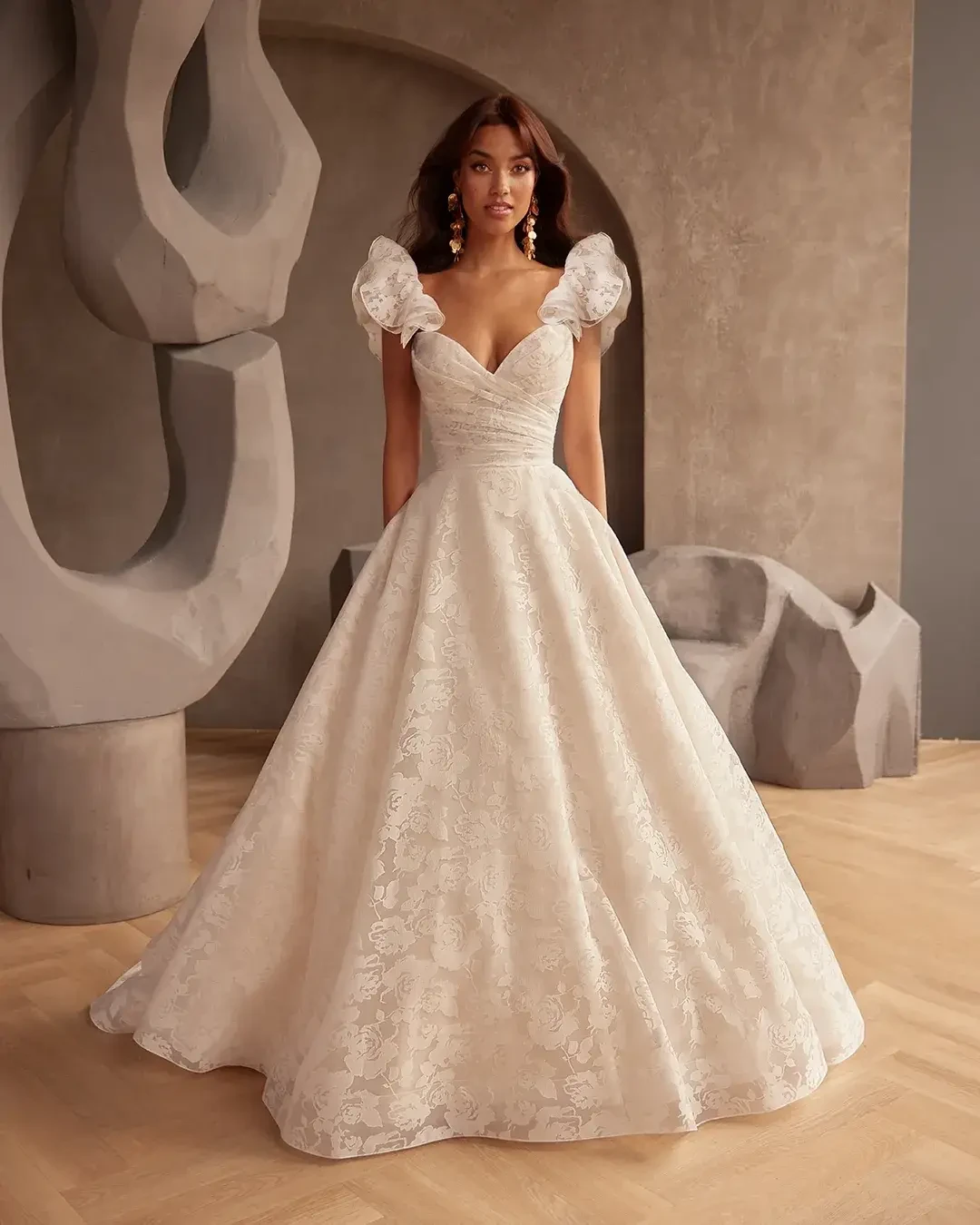 model is wearing a strapless ball gown with detachable puff sleeves