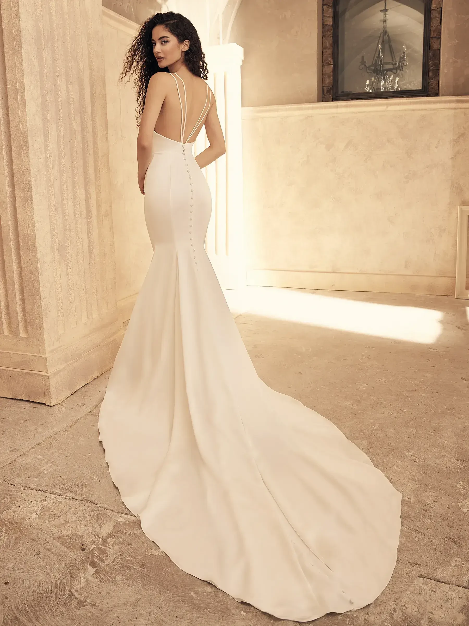 Model is wearing a wedding gown with a cowl neckline that softly drapes around the collarbone.