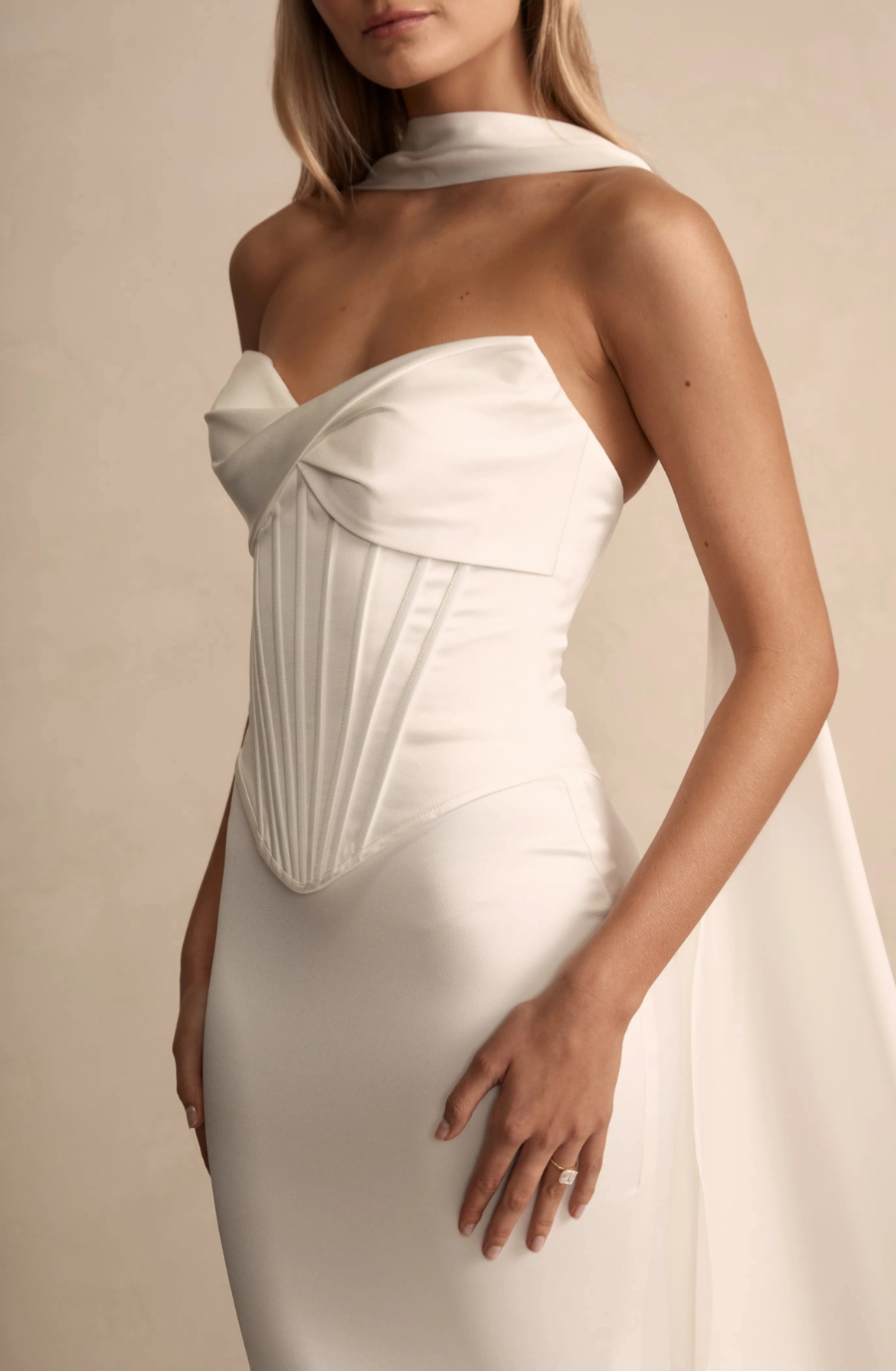 Model is wearing a wedding gown with a basque waist that elongates the torso and defines the silhouette.