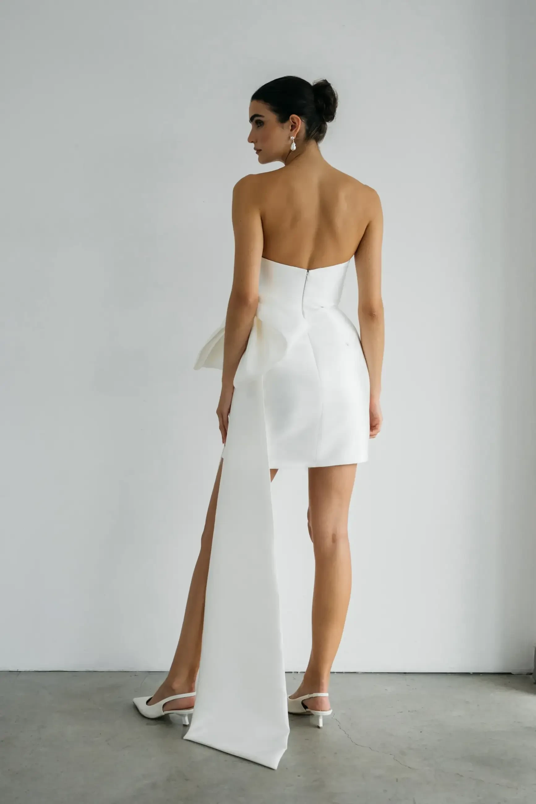 model is wearing a strapless bridal mini dress by jenny yoo