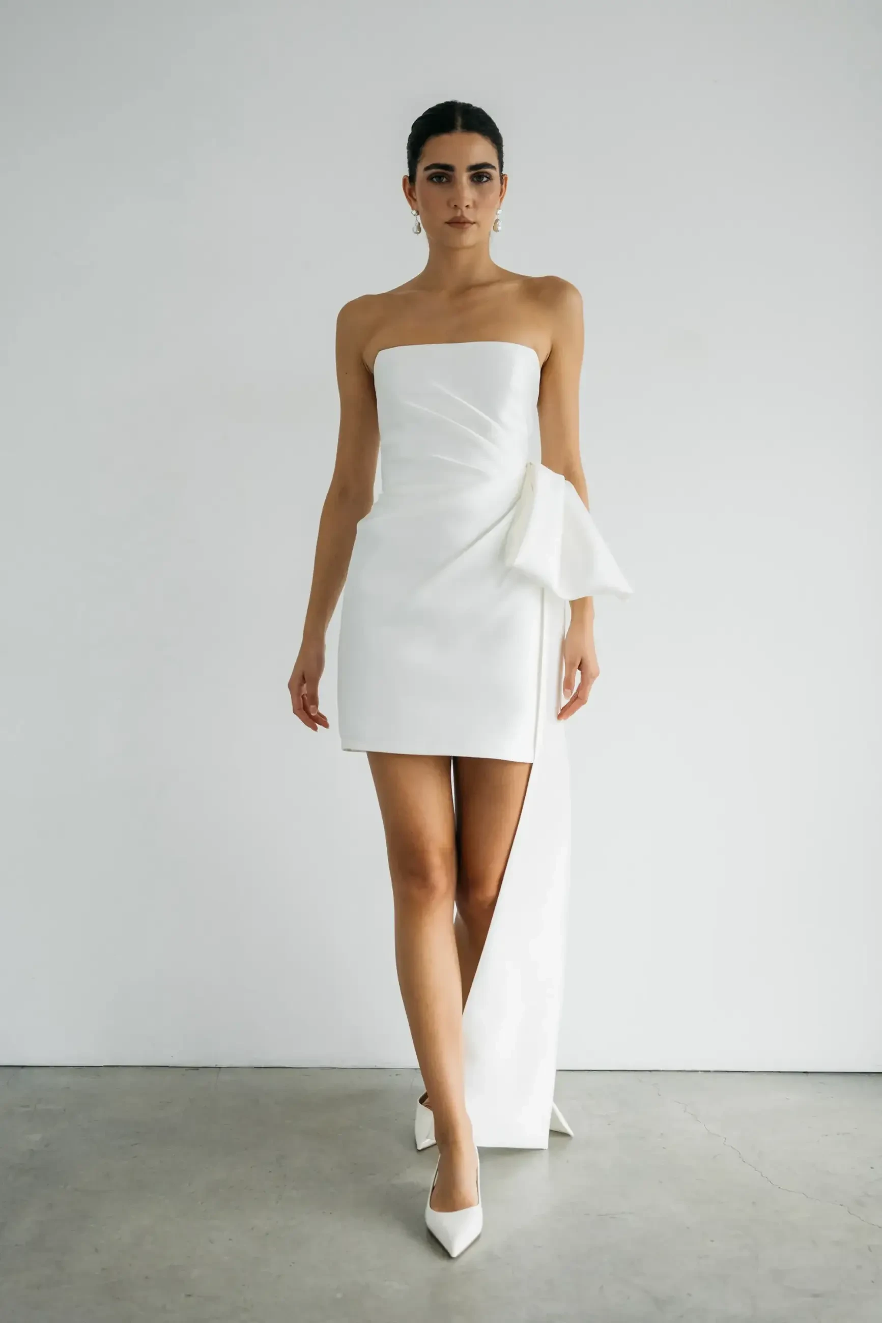 model is wearing a strapless bridal mini dress by jenny yoo